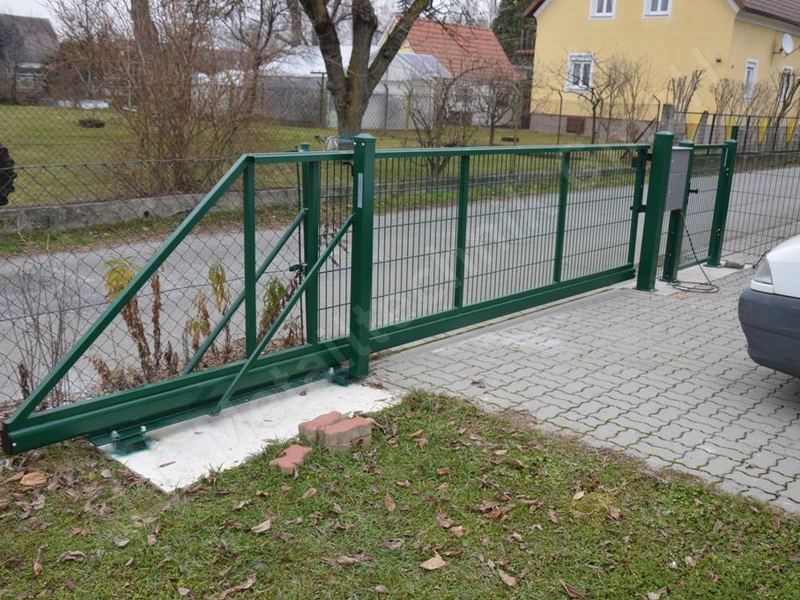 Gr&uuml;nes freitragendes Schiebetor mit Elektroantrieb und Steuers&auml;ule an einer Grundst&uuml;ckseinfahrt