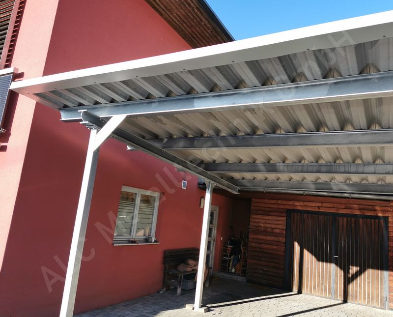 Anlehncarport aus wei&szlig; lackiertem Stahl mit Trapezblech-Pultdach an einem Wohnhaus