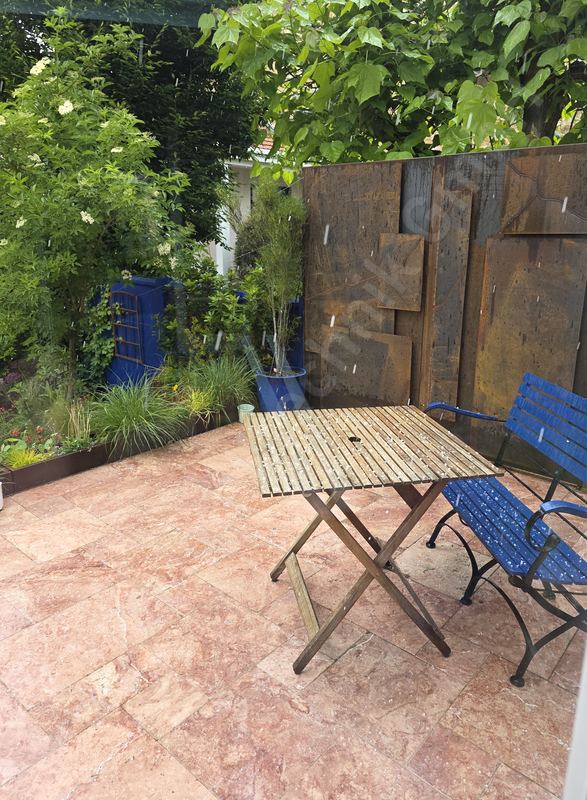 Sichtschutzwand aus Cortenstahl-Platten mit Edelrost-Patina an einer Gartenterrasse