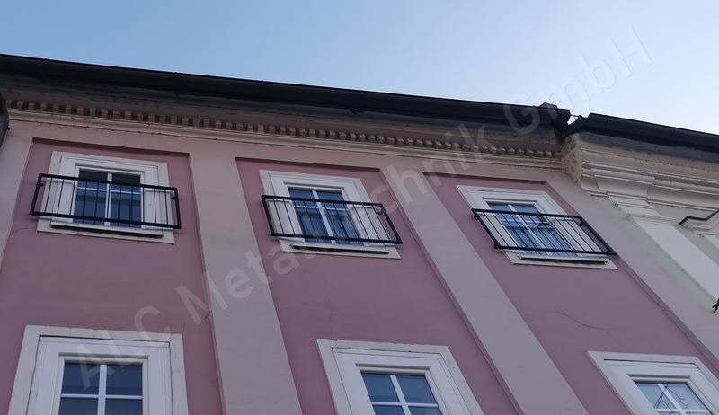 Franz&ouml;sische Balkone aus schwarz beschichtetem Stahl vor den bodentiefen Fenstern einer sanierten Altbaufassade