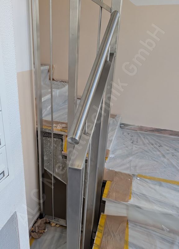 Edelstahl-Treppengel&auml;nder mit rundem Handlauf im Stiegenhaus eines Neubaus in K&auml;rnten