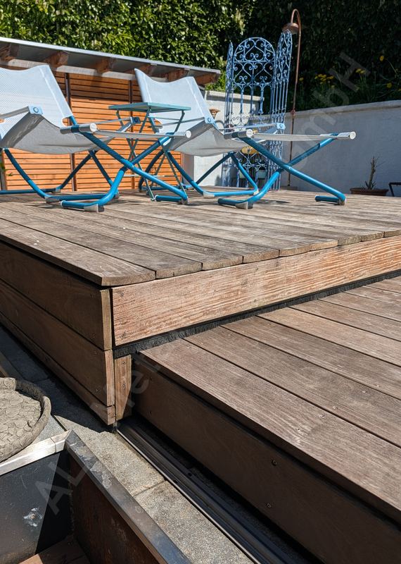 Verschiebbares Pooldeck aus Holz mit Liegest&uuml;hlen, seitlich ge&ouml;ffnet, F&uuml;hrungsschiene im Terrassenrand
