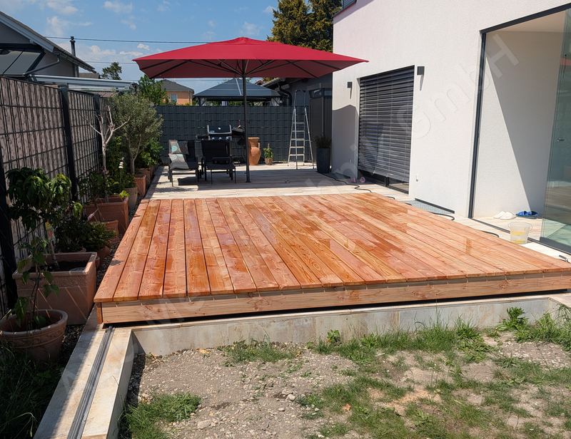 Pooldeck aus L&auml;rchenholz geschlossen neben einem modernen Wohnhaus, Terrasse mit Sonnenschirm