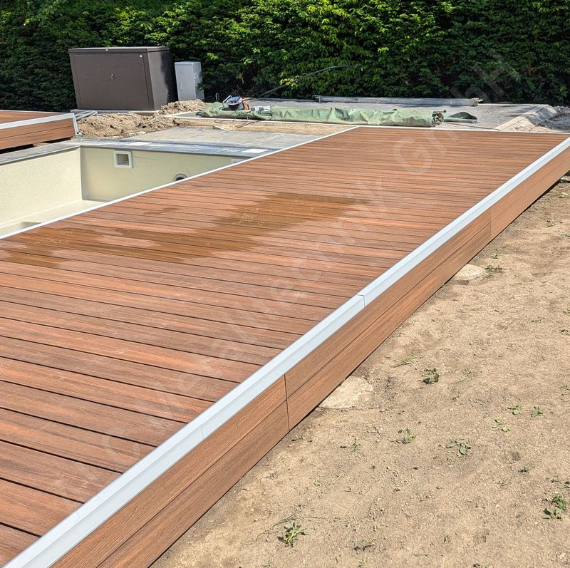 Begehbare Poolabdeckung mit braunem WPC-Belag, geschlossen &uuml;ber dem Pool, Gartenbaustelle in K&auml;rnten