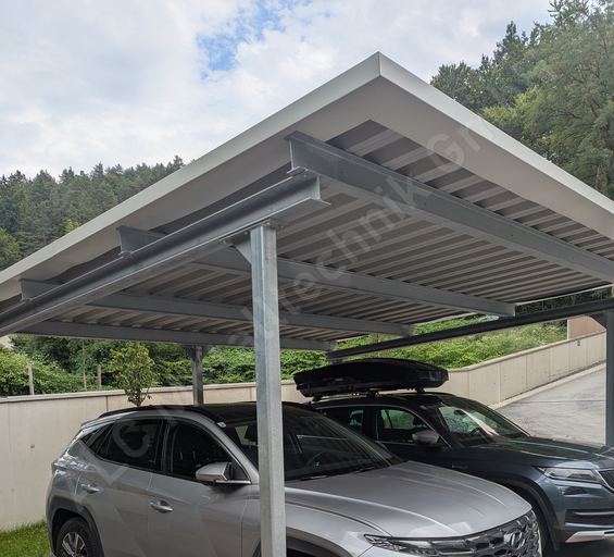 Doppelcarport aus verzinktem Stahl mit flachem Pultdach &uuml;ber zwei parkenden Fahrzeugen