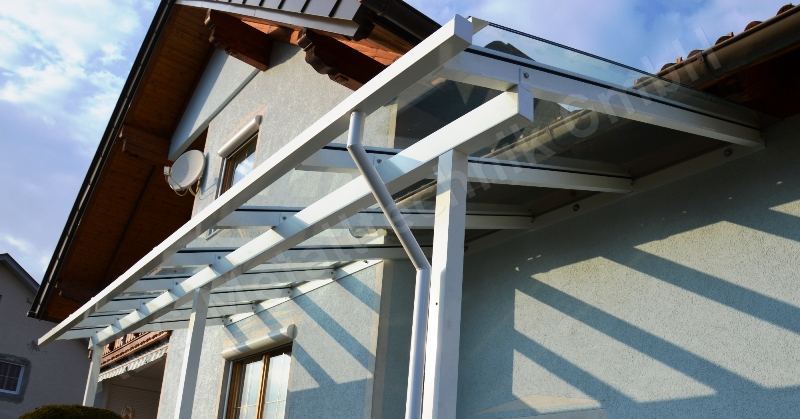 Balkon mit wei&szlig;em Glasgel&auml;nder und Vordach an einem Wohnhaus