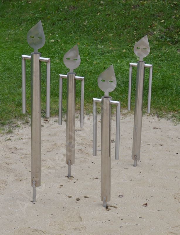 Kunstobjekt aus Edelstahl: vier Wächterfiguren aus Rohr und Blech als Blickfang in einer Gartenanlage