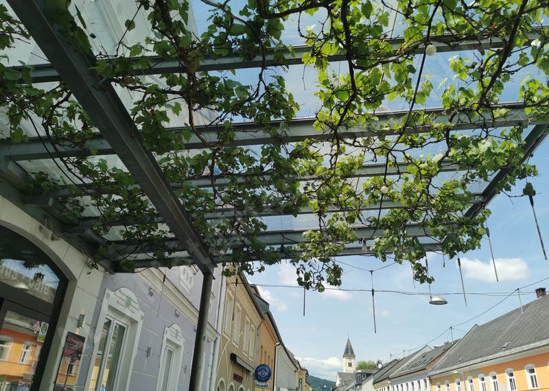 Stahl-Glas-&Uuml;berdachung mit verzinkten Tr&auml;gern &uuml;ber einem Gastgarten in der V&ouml;lkermarkter Innenstadt