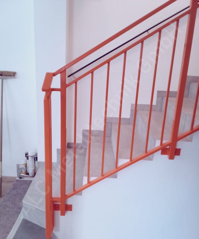 Orange pulverbeschichtetes Treppengel&auml;nder aus Stahl mit Handlauf an einer Innentreppe im Wohnhaus