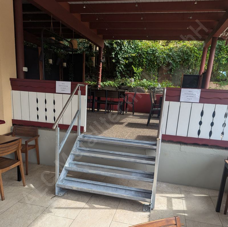 Feuerverzinkte Stahltreppe mit f&uuml;nf Stufen und Rundrohr-Handlauf als Zugang zur Gastgarten-Terrasse